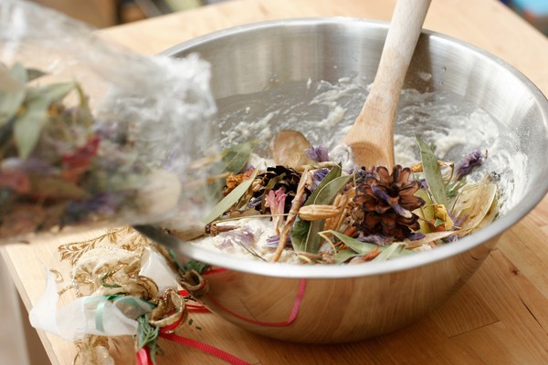 Adding potpourri A bag of potpourri being dumped into dough in a metal mixing bowl with a wooden spoon