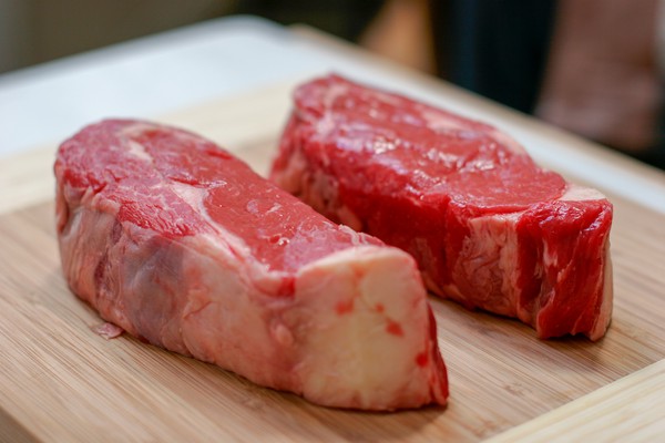 High quality meat Two New York strip steaks on a wooden cutting board