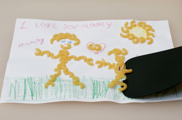 Scraping off the macaroni A spatula scraping macaroni off of a macaroni art drawing